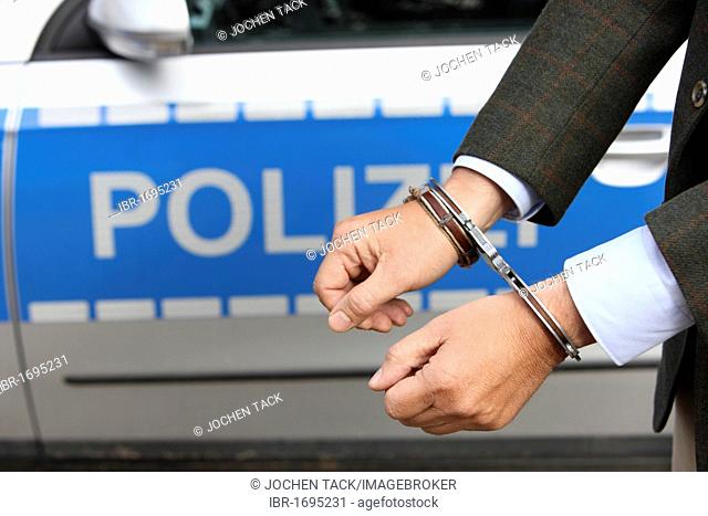 Man in a suit and in handcuffs