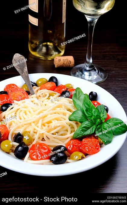 Spaghetti with olives, cherry tomatoes, sprinkled  Parmesan and basil