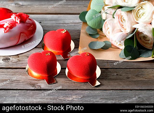 Red heart cacke desserts and buttercups on wooden background. dessert for breakfast on Valentine's Day