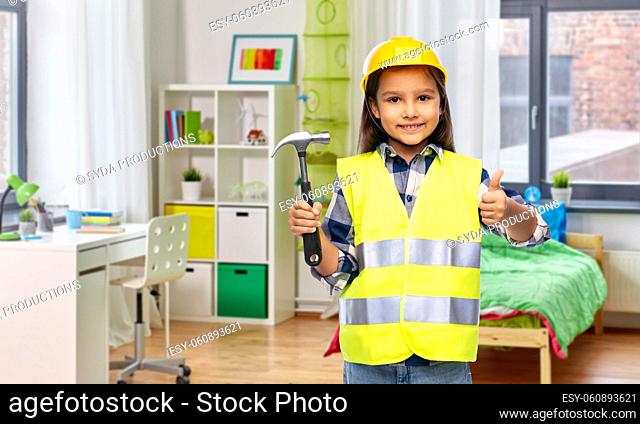 happy girl with hammer showing thumbs up at home