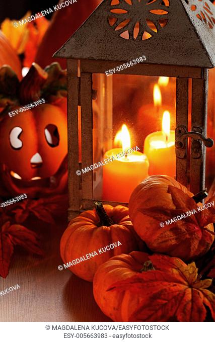 Lanterns with burning candles and pumpkins