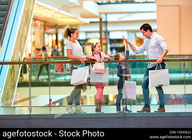 Vater und Sohn geben sich ein High Five beim Shopping im Einkaufszentrum