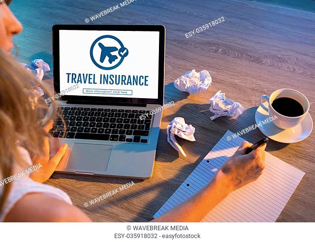 Woman using a computer with travel insurance concept on screen