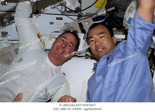 Following their successful spacewalk earlier in the day, astronauts Stephen K. Robinson, left, and Soichi Noguchi of the Japanese Aerospace Agency