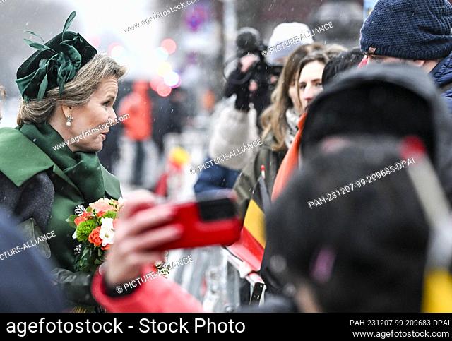 05 December 2023, Berlin: Queen Mathilde of Belgium with a bouquet of flowers in her hands is greeted by waiting spectators with Belgian flags at the...