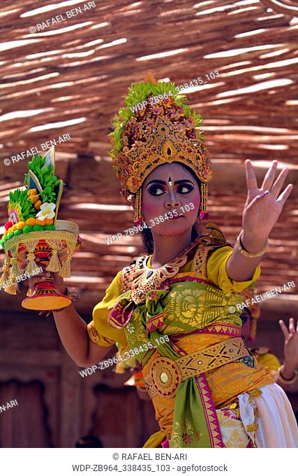 Balinese woman dancing Tari Pendet Dance. Pendet is a traditional dance from Bali, Indonesia, in which floral offerings are made to purify the temple as a...