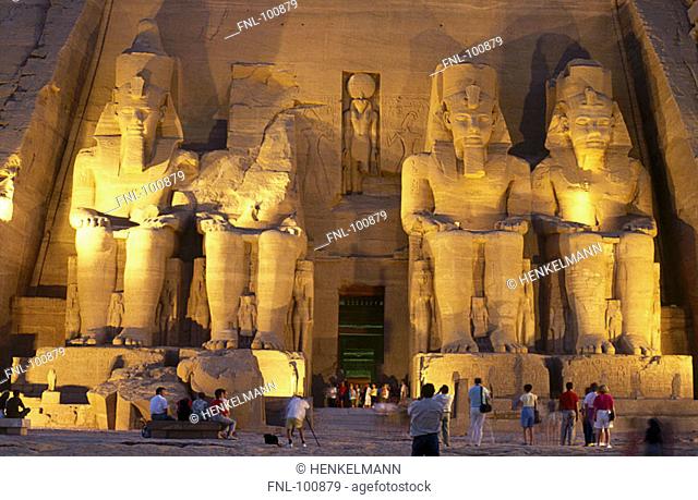 Tourists at Egyptian temple lit up at night, Great Temple of Rameses II, Abu Simbel, Egypt