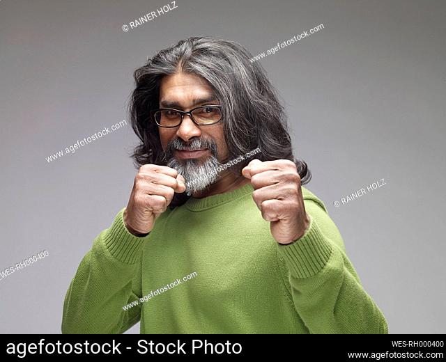 Mature man showing fists, looking confident, portrait
