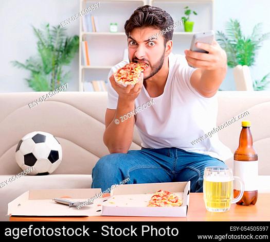 The man eating pizza having a takeaway at home relaxing resting