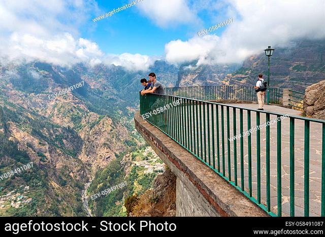 Madeira Island, Portugal - August 01, 2014: People wondering a view from high-level viewpoint at sun-drenched mountain village Curral das Freiras at Madeira...