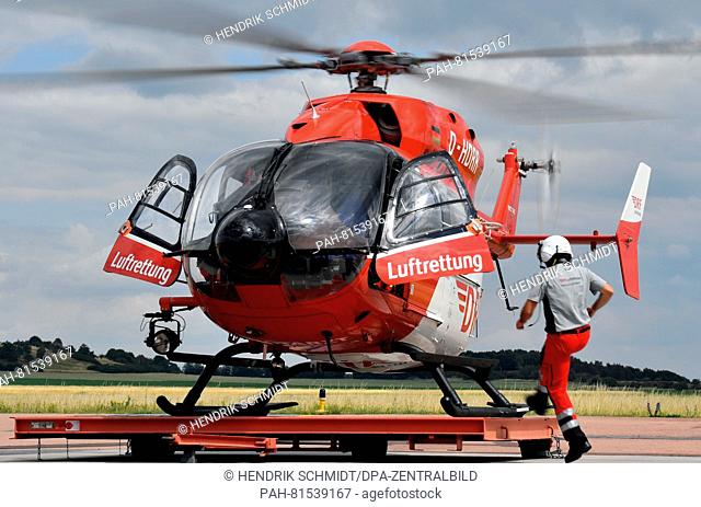 A crew member of the German Air Rescue (DRF) walking towards a helicopter at the station on the airfield Oppin in Landsberg, Germany, 21 June 2016