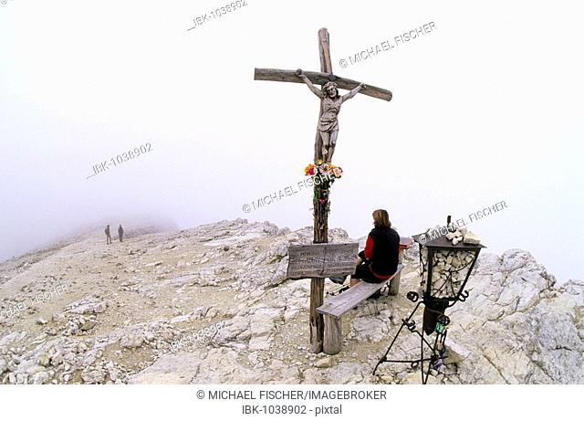Female hiker next to the cross on the peak of Mount Kleiner Lagazuoi, 2778 m, Cortina d'Ampezzo, Ampezzo Dolomites, Italy, Europe