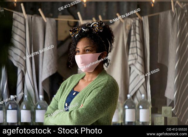 Portrait confident female shop owner in pink face mask
