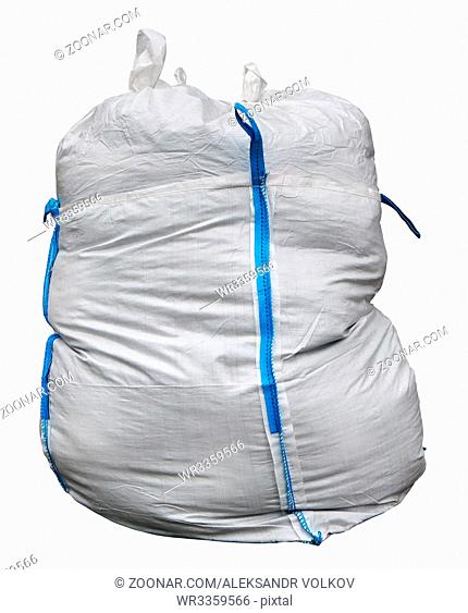The big bag for construction debris is made of a white synthetic sacking and has blue loops for transportation. Isolated with patch