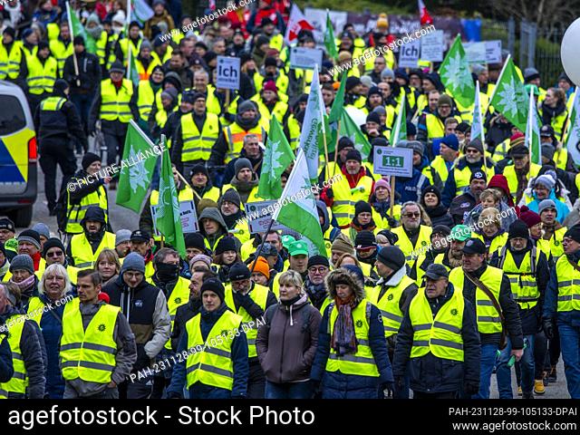 28 November 2023, Mecklenburg-Western Pomerania, Schwerin: Protesters march through the city center during an action in the ongoing wage dispute in the public...