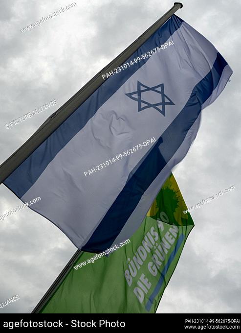 14 October 2023, Baden-Württemberg, Weingarten: The Israeli flag flies next to the party flag at the state delegates' conference of Bündnis 90/Die Grünen...