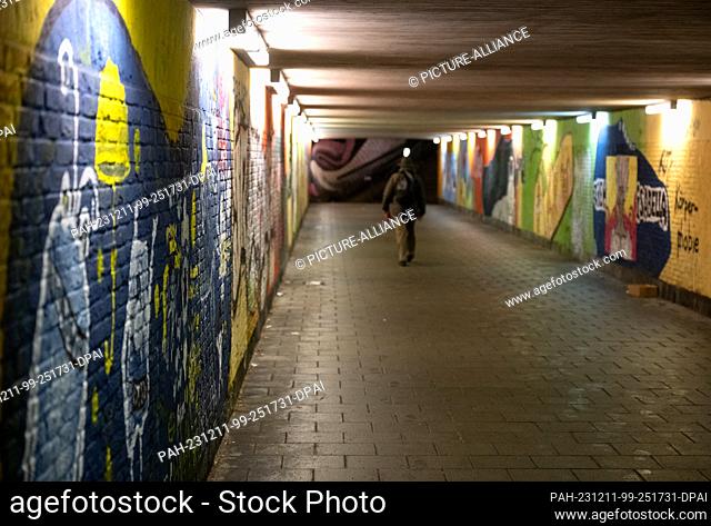 11 December 2023, Bavaria, Munich: A man walks through an underpass in the early morning. Photo: Sven Hoppe/dpa. - Munich/Bavaria/Germany