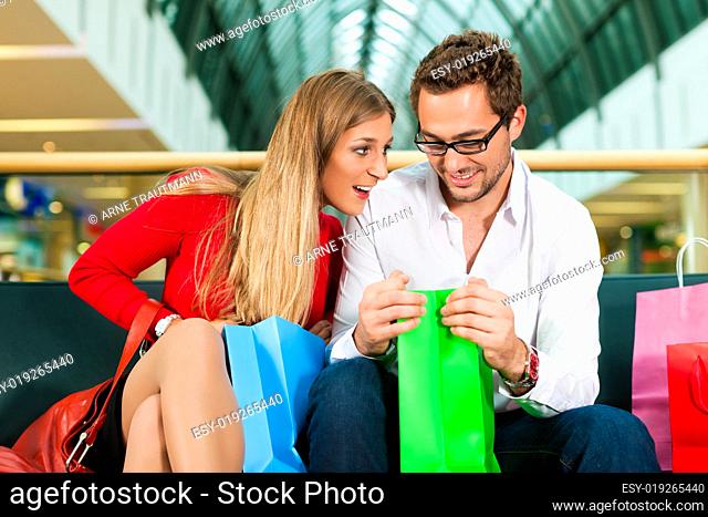 Mann und Frau in Kaufhaus mit Tüten