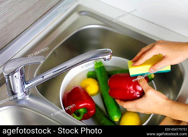 COVID-19 Pandemic Coronavirus Close up woman hands washing vegetables with sponge to prevent infection in time of Coronavirus Disease 2019