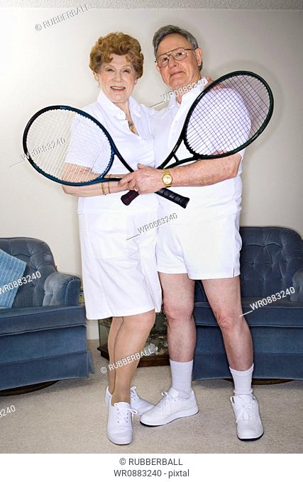 Portrait of senior couple with tennis rackets