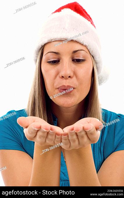 Closeup of a woman with Christmas hat blowing something from her hands isolated over white background