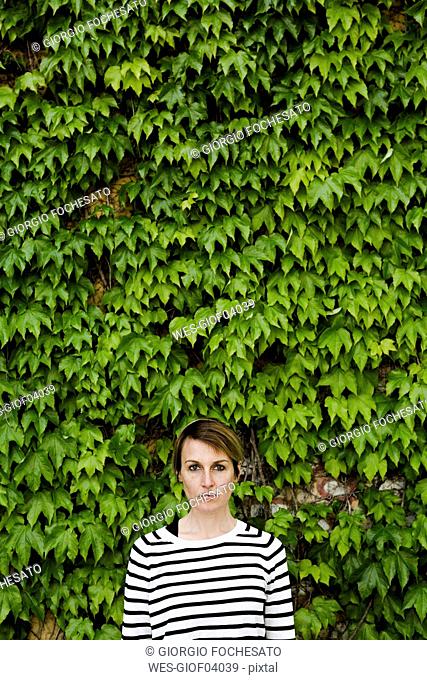 Portrait of woman in front of facade greenery