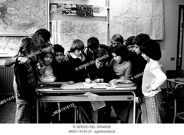 Some pupils of a classroom gathered around a desk. Although the terrible earthquake occurring in Friuli, the pupils of Lusevera (a village near Udine)
