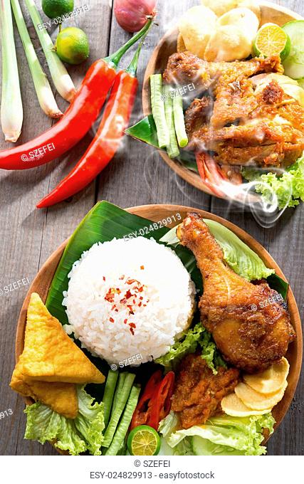 Popular delicious Indonesian local food nasi ayam penyet, indonesian fried chicken rice with sambal belacan. Fresh hot with steam smoke