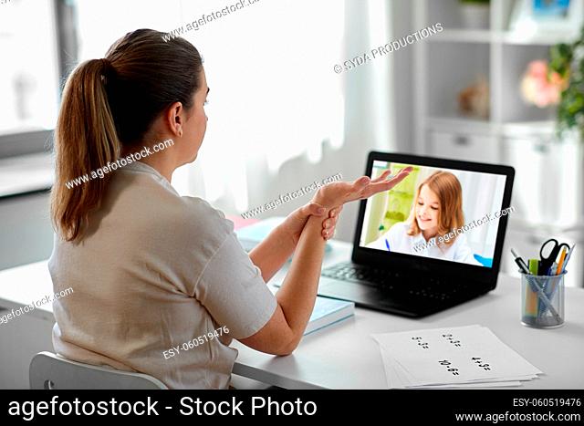 tired teacher with laptop touching wrist at home