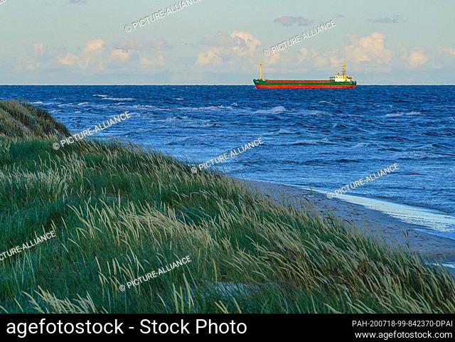 08 July 2020, Denmark, Dueodde: A ship near the Baltic coast of Dueodde in the light of sunset at the south-eastern tip of the Danish island of Bornholm