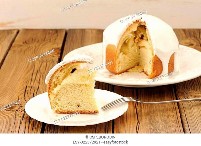 Kulich, traditional Russian Easter cake with icing, cut, on wood