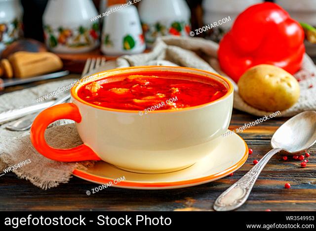 Goulash in a ceramic bowl on an old wooden table, selective focus