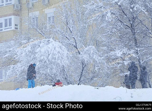 People with sleds as snow falls in a park of Mostoles on January 9, 2021 in Madrid. Spain is on red alert for a second day due to storm Filomena