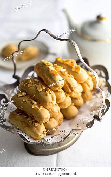 Caramelised white chocolate eclairs with almond milk cream and salted almond brittle served with tea