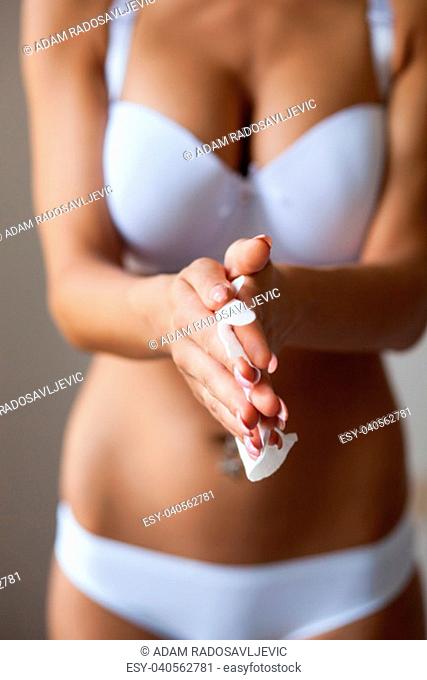 Sexy woman clean hands with wet wipes, body breast lingerie panties in blurred background