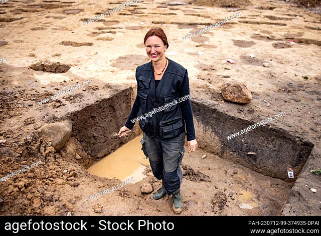 12 July 2023, Schleswig-Holstein, Flintbek: Archaeologist Katahrina Schmeiduch is standing by traces of settlements dating from the 4th to 5th century BC from...