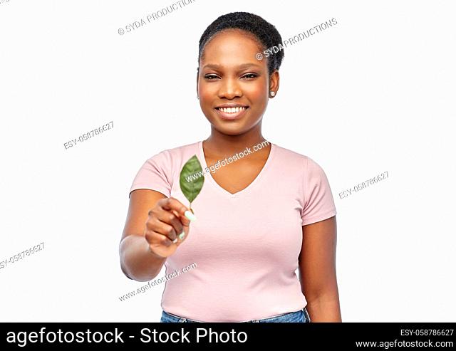 smiling african american woman holding green leaf