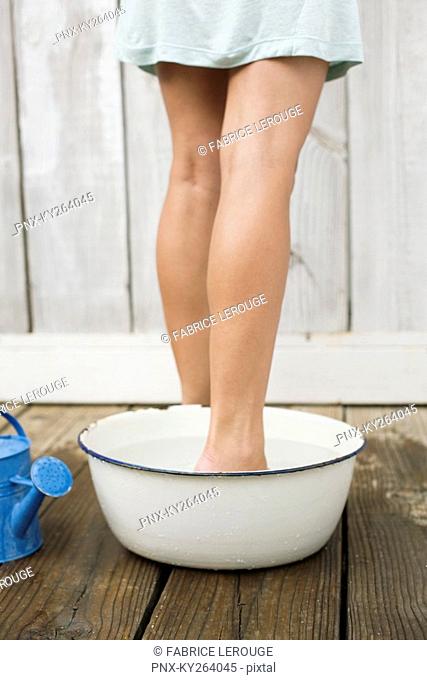 Woman washing legs in the bathroom