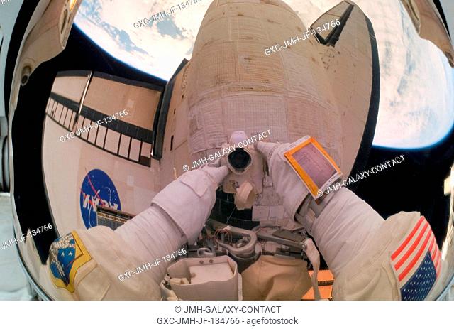The helmet visor of astronaut John Danny Olivas, STS-117 mission specialist, serves as an easel of sorts as it reflects a pictorial account of a portion of a...
