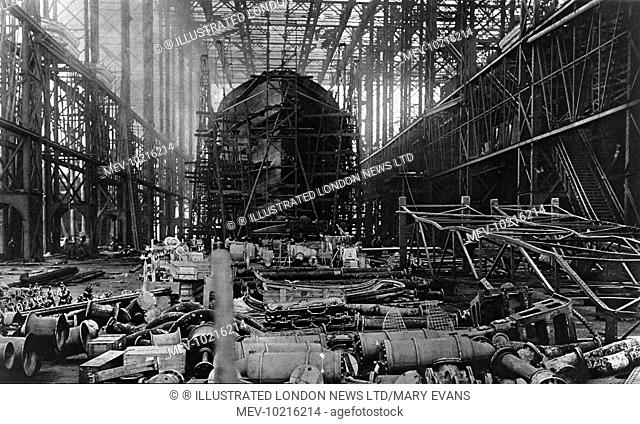 Scene inside a naval ship-building yard (unspecified) during World War I. A destroyer under construction on stocks