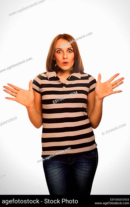 Surprised excited brunette woman throws up his hands opened her mouth isolated in a black dress emotion