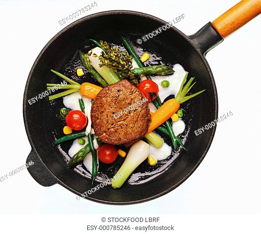 Beef fillet in vegetable ring with herb butter in pan