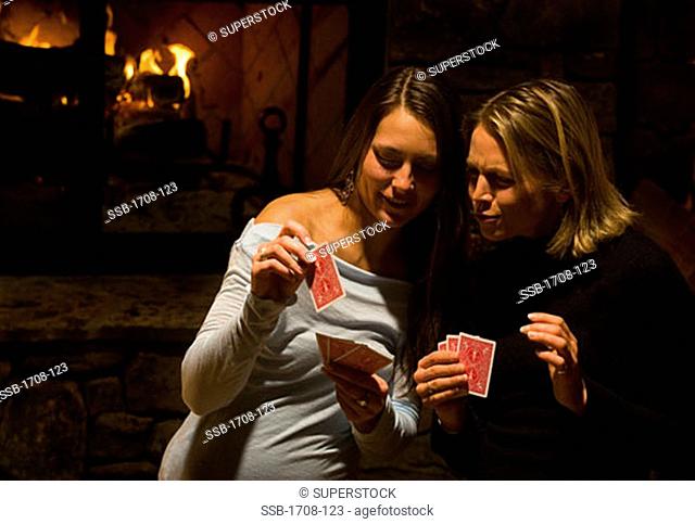 Young woman and a mid adult woman playing cards