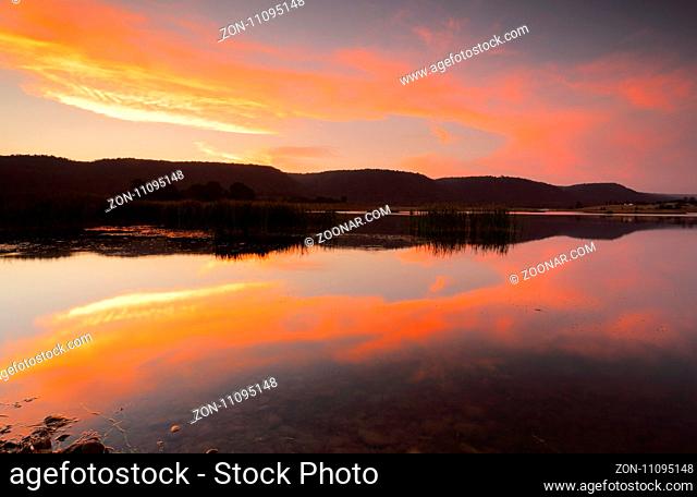 Splendid vivid colours and mirrored reflections in the lake.  Location Boorooberongal Lake Penrith Australia