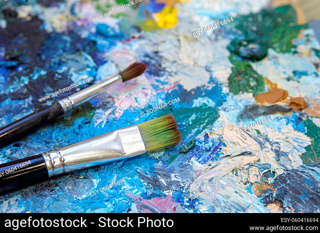 Abstract artistic background from an old palette with paints dried on it. The concept of art and creativity