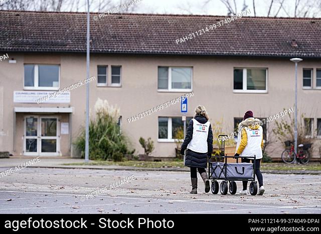 08 December 2021, Baden-Wuerttemberg, Heidelberg: Social workers walk past homes at the refugee arrival center on the site of the former U.S