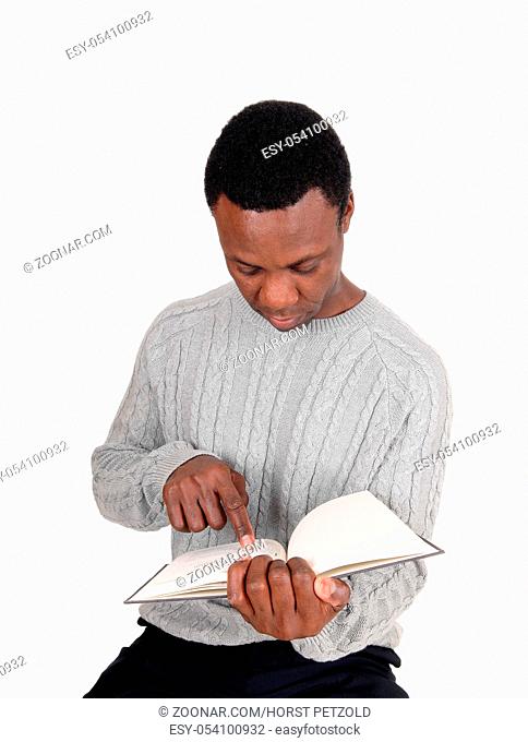 A handsome serious young African American man sitting and holding his book and pointing at it, isolated for white background