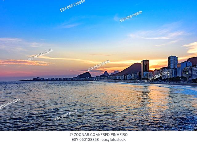 Leme and Copacabana beaches in Rio de Janeiro during sunset with its buildings, and the mountains in the background