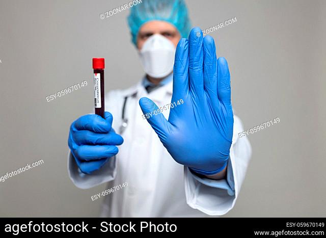 Health worker wearing a respiratory mask, holding the Coronavirus Covid-19 blood test sample