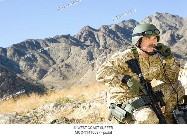 Soldier using field phone in mountains